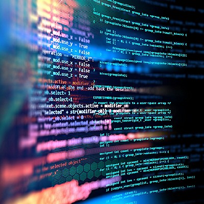 Colorful computer code displayed on a screen, with lines of text in blue, green, and pink hues. The abstract background creates a dynamic tech feel.