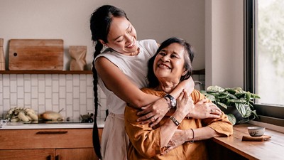 Older mother and daughter in the kitchen hugging