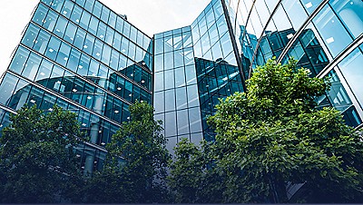 exterior of glass office building with trees outside