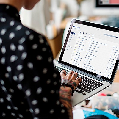 Professional checking email on laptop at desk