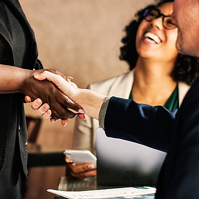 Two professionals shaking hands during a business meeting.