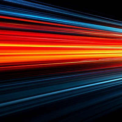 Dynamic light trails in vivid red, orange, and blue streak diagonally against a black background, creating a vibrant sense of motion and speed.