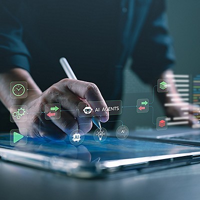 A person interacts with a tablet displaying various app icons on its screen.