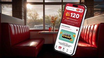 A smartphone displaying a rewards app hovers over a retro diner with red booths. The screen shows "Booth Bucks" rewards, conveying a promotion.