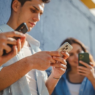 A group of people looking at the phone and chatting.