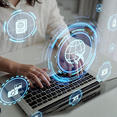 Hands typing on a laptop keyboard, overlaid with digital travel icons like a globe, airplane, and passport, conveying a futuristic travel theme.