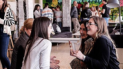 A lively indoor setting featuring a group of people engaged in casual conversations.