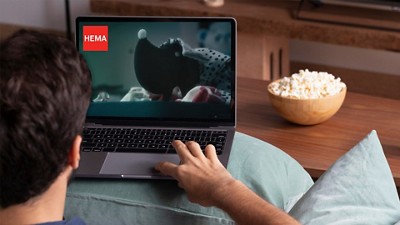 Young man watching a video on his computer with popcorn