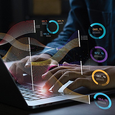 Hands typing on a laptop with data points showing