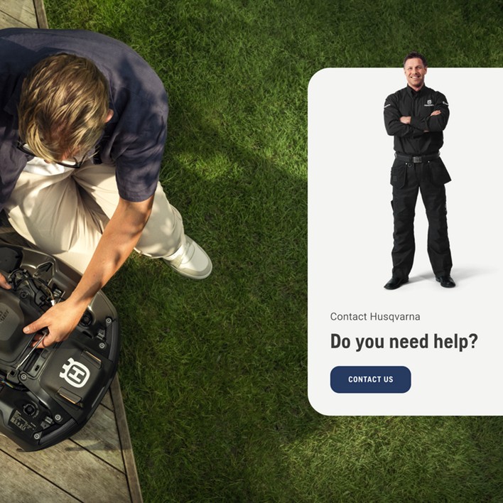 Person adjusting a Husqvarna robotic lawn mower on a deck beside grass, with a help contact banner on the right.