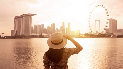Woman looking at skyline with a ferris wheel 