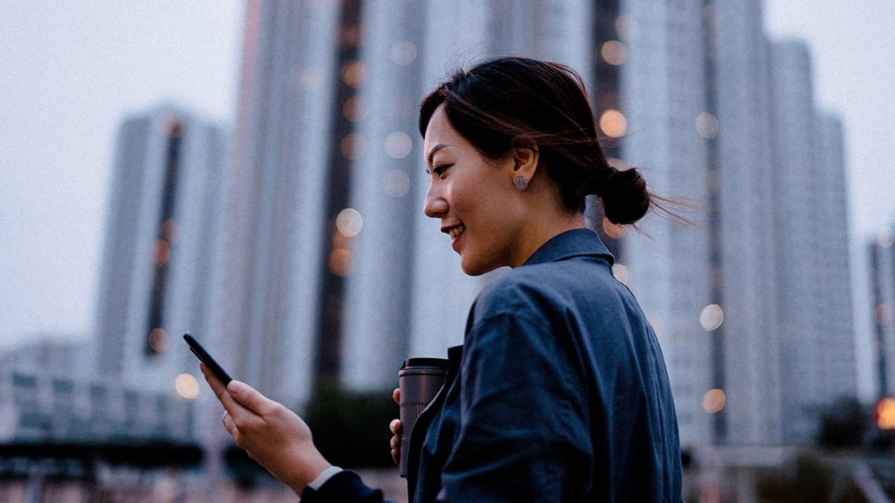 woman on phone in front of buildings