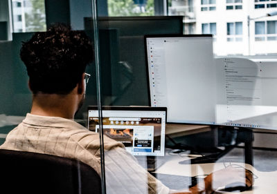 A colleague working behind his computer and supportive screen