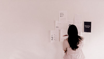 Person looking at pieces of paper on a wall