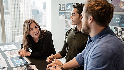 A group of people talk over a storyboard