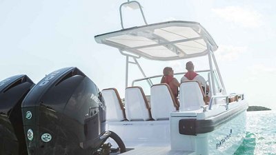 A couple drives their fishing boat on the ocean