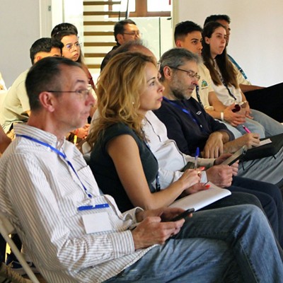 A group of people sitting at a conference listening intently