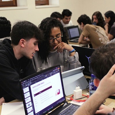A man and a woman with glasses focusing and looking at a tablet