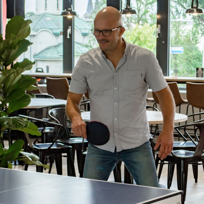 A colleague playing pingpong at our office