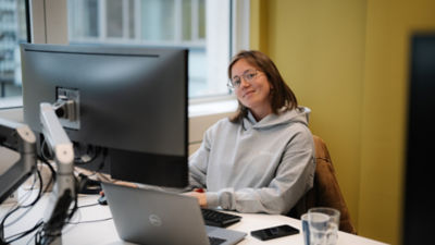 A view into our Merkle Netherlands office, with a colleague, sitting in a chair while drinking coffee