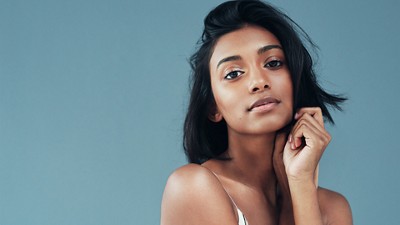 Young woman posing with clear and glowing skin