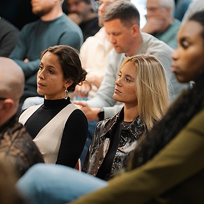 An audience where two people are focused looking at a presentation that has been given.