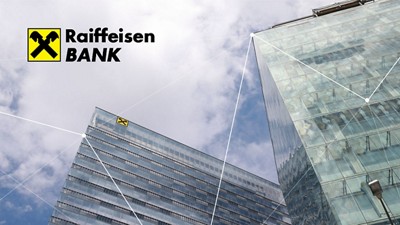 A glass skyscraper seen from below against the sky, with the Raiffeisen Bank logo.