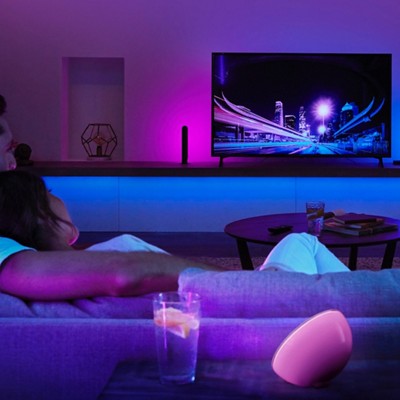 A couple lounges on the couch watching TV