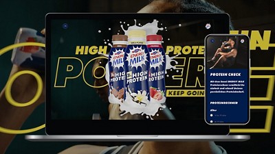 Laptop and smartphone display an ad for Energy Milk High Protein drinks with the slogan ‘Keep Going’ and a protein calculator app.