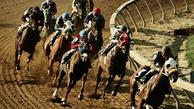 Horses racing around a track