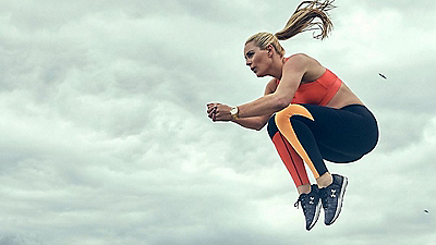 Una mujer con ropa Under Armour salta en el aire