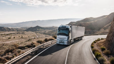 Volvo Truck on the road, surrounded by mountains and cloudy sky