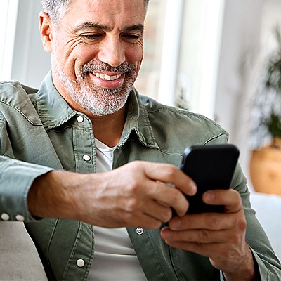 Man smiling while using a smartphone