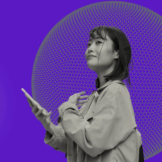 Woman holding phone in front of purple background