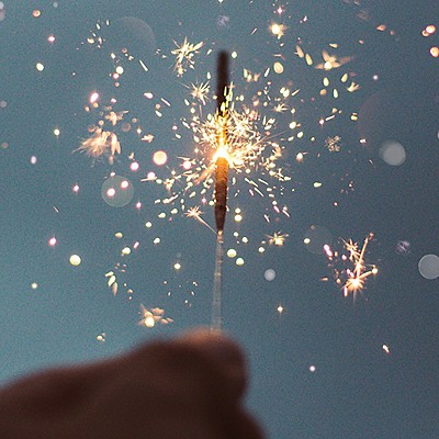 A hand raised with a glowing sparkler