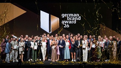 Group photo of German Brand Award 2026 winners and guests on stage with confetti and event branding.