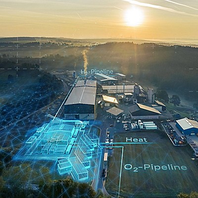 Luftaufnahme einer Fabrik mit digitalen Überlagerungen, die Wasserstoff- und Sauerstoffleitungen sowie Wärmequellen bei Sonnenaufgang anzeigen.