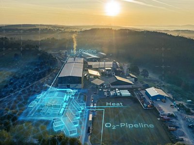 Luftaufnahme einer Fabrik mit digitalen Überlagerungen, die Rohrleitungen für Wasserstoff (H2) und Sauerstoff (O2) sowie ein Heizsystem bei Sonnenaufgang zeigen.