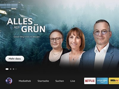 Ein Werbebild mit drei Personen vor einem Hintergrund aus grünen Wäldern und dem Text „ALLES AUF GRÜN – Dieser Weg führt ins Morgen“.