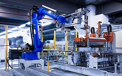 Industrial robotic arm operating automated manufacturing equipment on a smart factory production line.