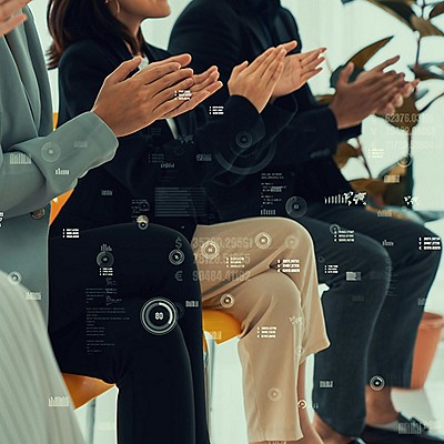 Team members in business attire applauding and transparent digital data and graphs overlaid on the image.