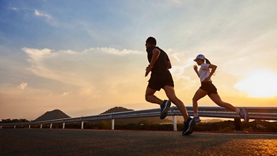 Two people jogging on the streets at sunset