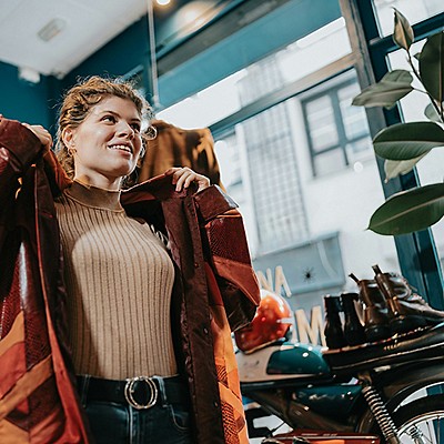 A woman trying on a new coat