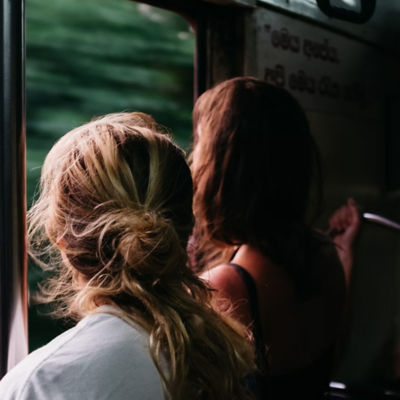 Two passengers stare out a train window