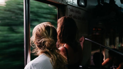 Two passengers stare out a train window