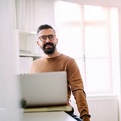  A man works at a desk with a laptop in front of him